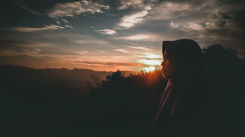 Side view of woman wearing hijab during sunset
