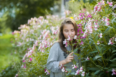 Cute girl smelling flower outdoors