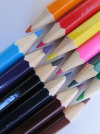 High angle view of colored pencils on white background