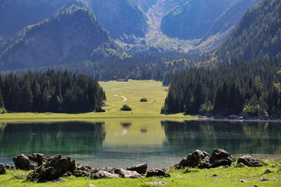 Scenic view of lake by trees against mountain