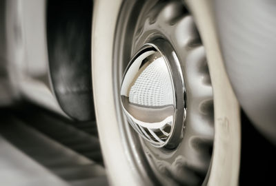 Close-up of car tire with building reflection