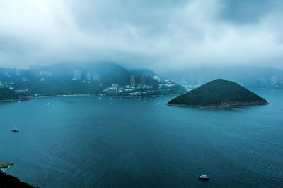 Scenic view of sea by city against sky