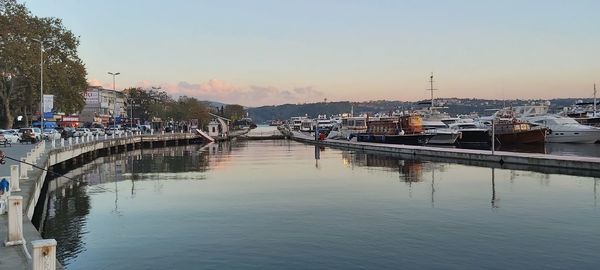 Boats in harbor at sunset