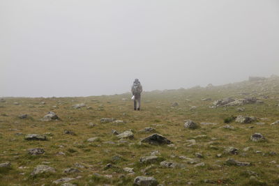 Full length of man standing on field against clear sky