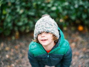 Portrait of young boy standing against plants