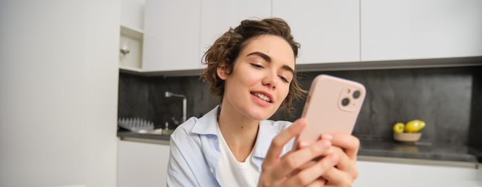 Young woman using mobile phone at home