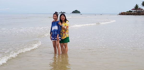 Portrait of mother and daughter standing at beach