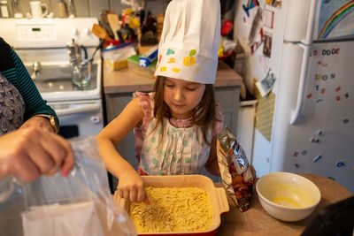 High angle view of girl having food at kitchen