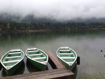 Boats moored in lake against sky