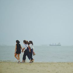 Rear view of tourists on beach