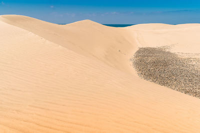 Sand dunes in desert against sky