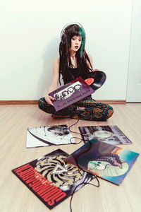 Portrait of young woman sitting on floor at home