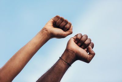 Low angle view of man hand against clear sky