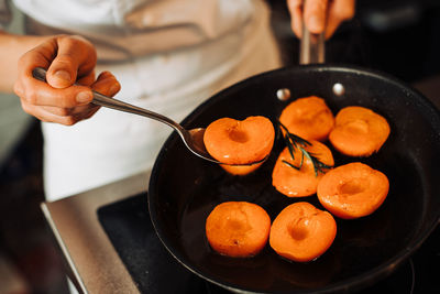 Apricots in a frying pan, confiture preparation in a restaurant