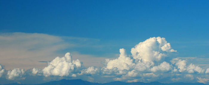 Sun shining through clouds over mountains