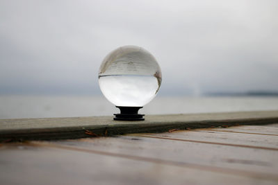 Close-up of light bulb on table against sea