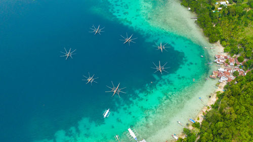 Aerial view of village of fishermen with houses on the water, with fishing boats, samal island. 