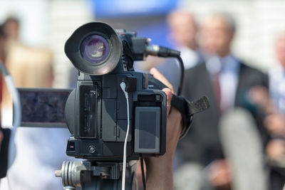 Close-up of video camera against people