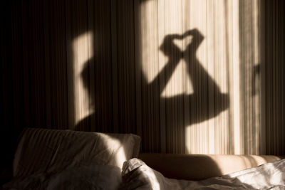 Shadow of person on bed at home