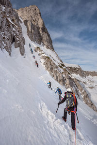 Rear view of hikers on snow capped mountain