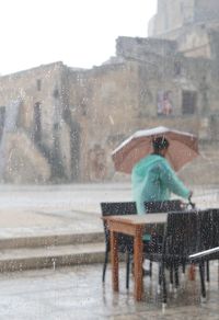 Man on street against buildings in city during winter