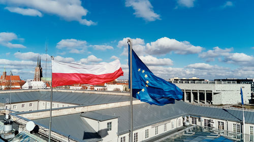 Waving polisg flag and european union flag on building