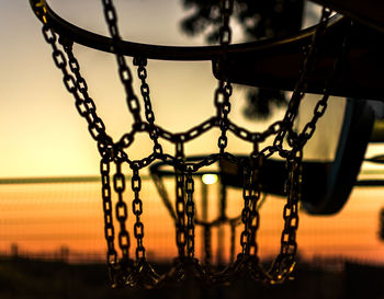 Close-up of basketball hoop during sunset