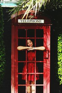 Woman standing in telephone booth