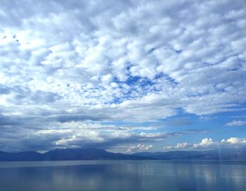 Scenic view of lake against cloudy sky