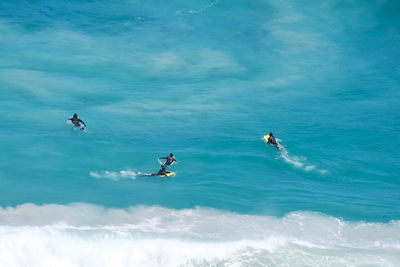 People paddleboarding in sea