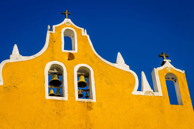 Low angle view of historic church against clear blue sky