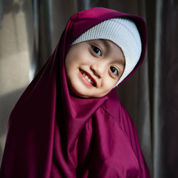 Portrait of a happy muslim toddler girl with hijab. natural light, selective focus.