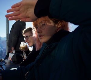 Portrait of woman shielding eyes by man drinking coffee in cafe