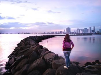 Rear view of woman looking at city against sky