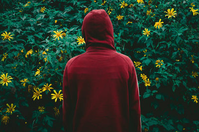 Rear view of man standing against plants