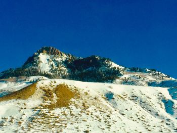 Scenic view of snowcapped mountains against clear blue sky