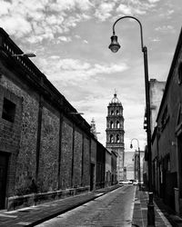 Street amidst buildings against sky in city