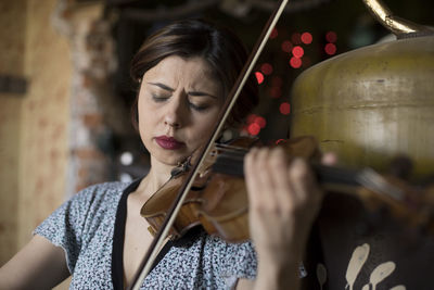 Close-up of woman with eyes closed playing violin