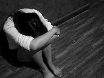 High angle view of girl sitting on hardwood floor