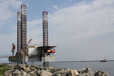 Commercial dock by sea against sky