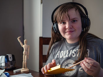 Portrait of girl holding pencil at home