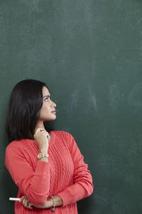 Female teacher looking at blackboard