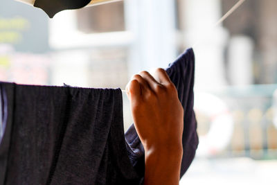 Cropped hand drying clothes on line