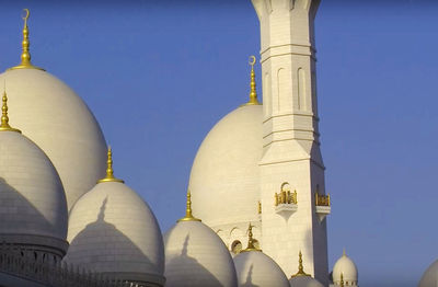 Low angle view of mosque against clear blue sky