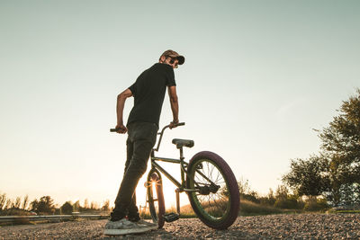 Man riding bicycle on road against sky