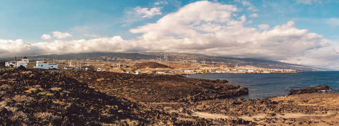 Aerial view of sea and city against sky