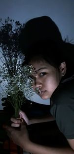 Portrait of a young woman holding plant