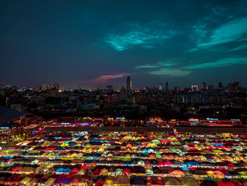 High angle view of illuminated city against sky at night