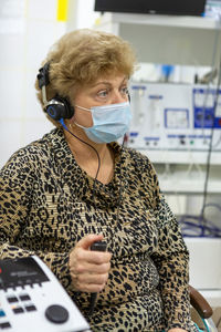 Audiologist checks the hearing of an older woman