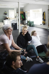 Smiling people talking together in gym